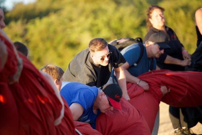 Virgin Balloon Flights crew and passengers packing away the red balloon after landing