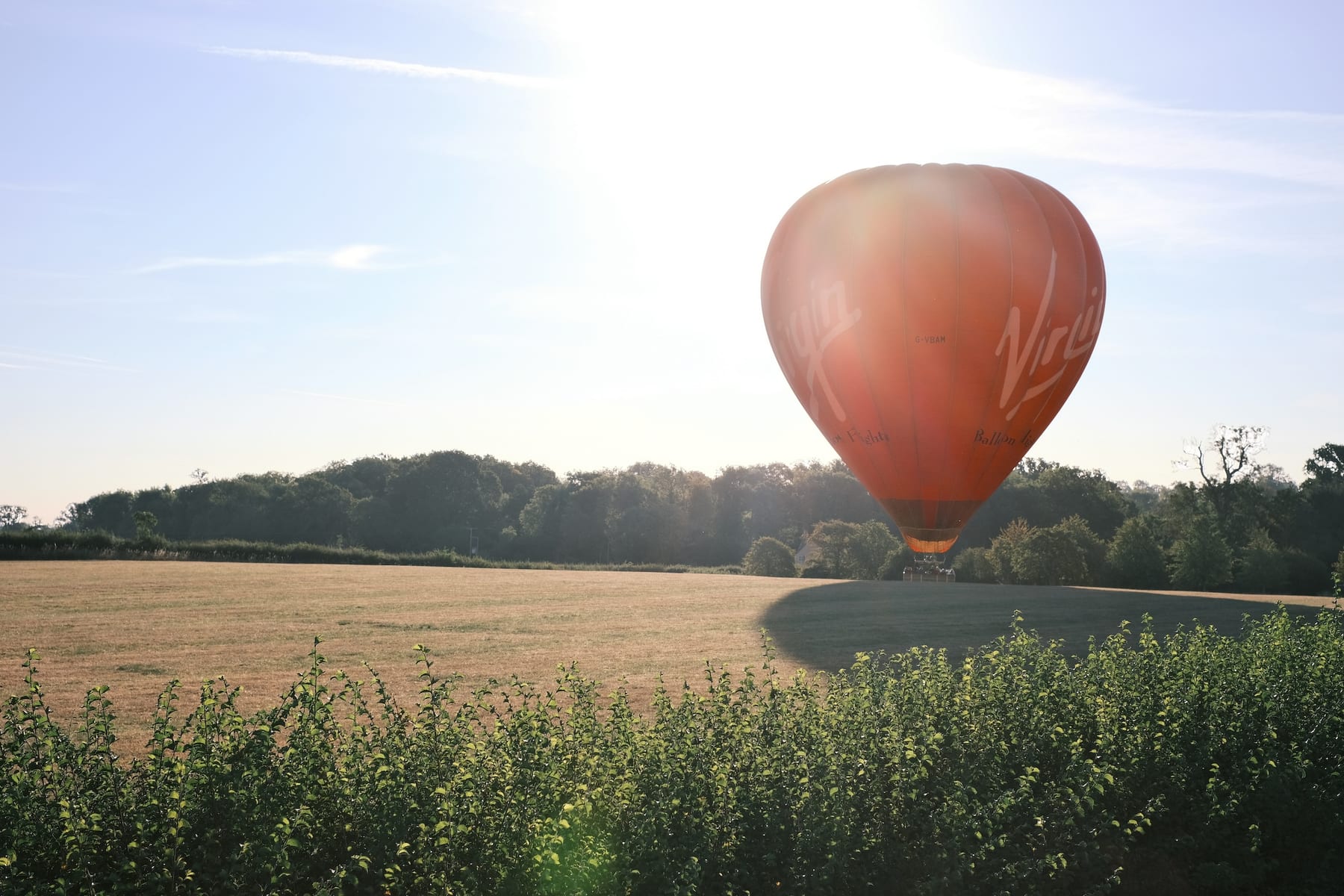 Virgin hot air balloon floating above a sunlit field, an unforgettable Christmas gift experience